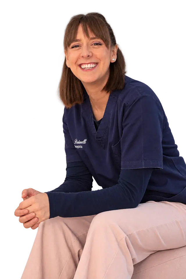 Giulia Pisciarelli, osteopata, seduta e sorridente con la divisa blu