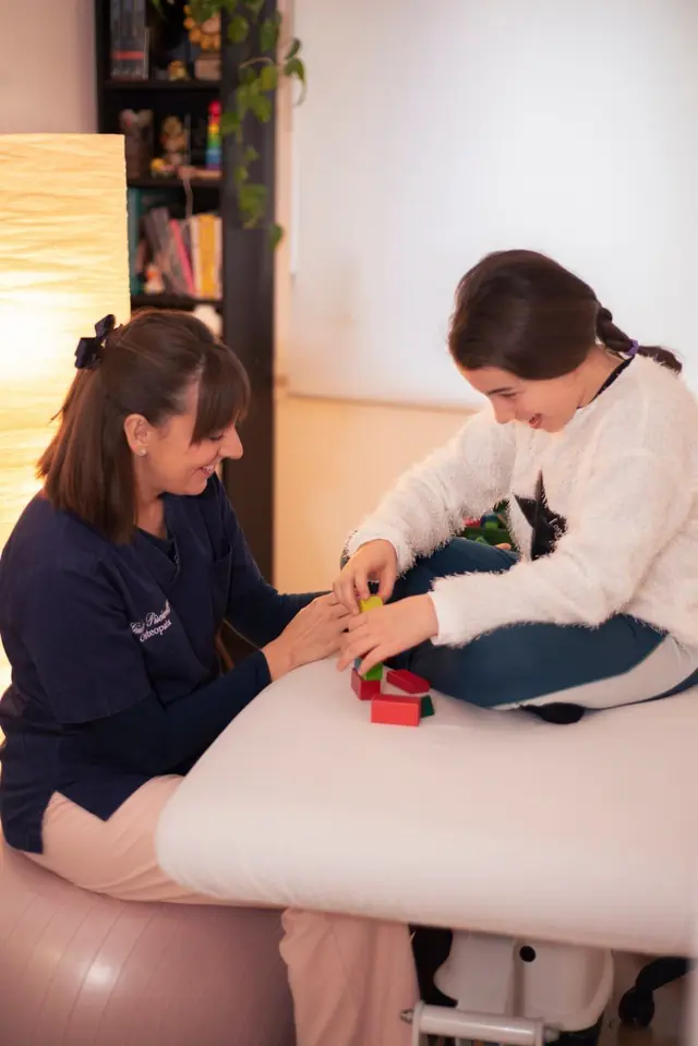 Giulia e una bambina giocano insieme con dei blocchi sul lettino